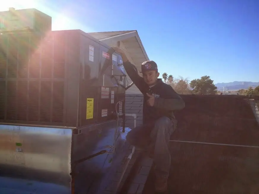HVAC technician performing AC Tune-Up on a rooftop unit in Sedalia
